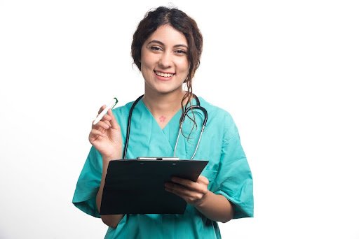 Smiling medical assistant in scrubs holding a clipboard and pen, representing online medical assistant career training.